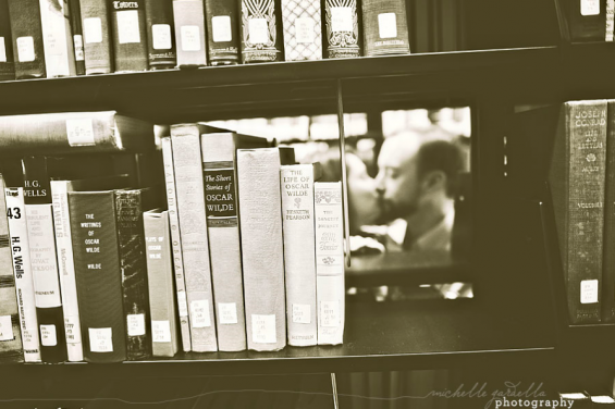 couple kissing behind books bw