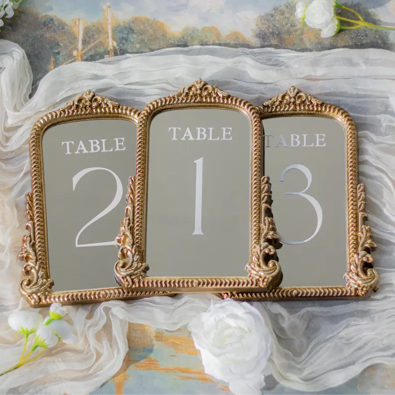 mirror wedding table numbers with white writing and intricate frame