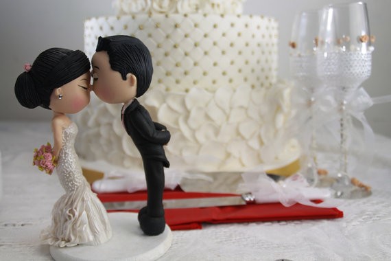 cute couple kissing cake topper | figurine cake toppers that look like you | by artifice producciones | https://emmalinebride.com/reception/figurine-cake-toppers/