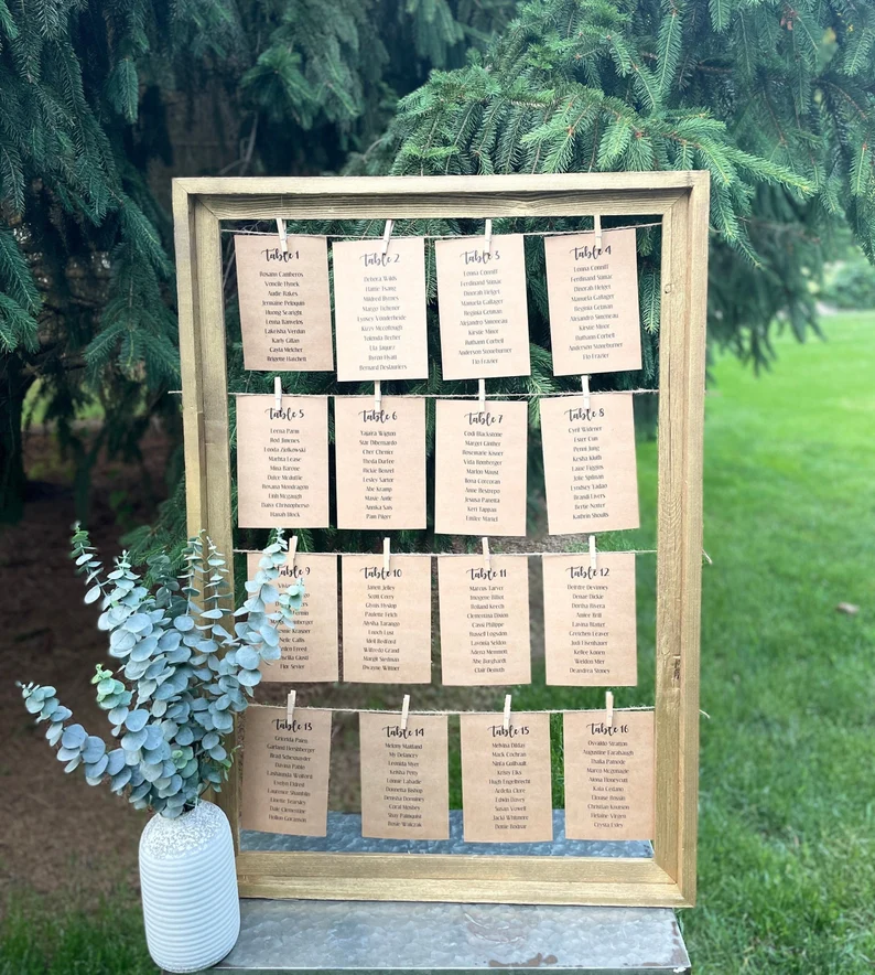 framed wedding seating chart with twine and clothespins and cards