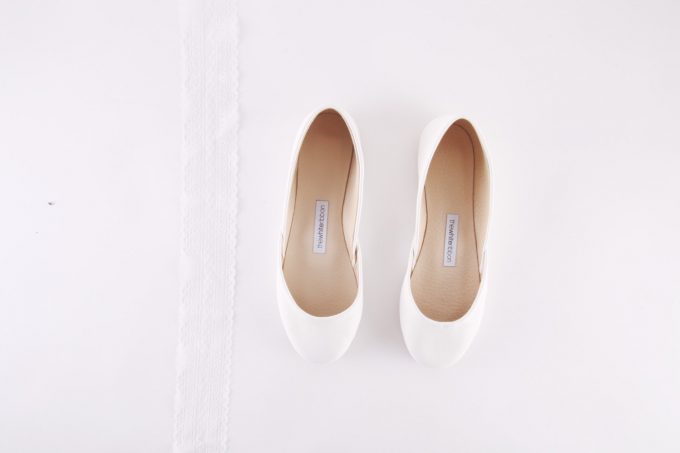 White Ballet Flats by The White Ribbon | 21 Wedding Flats That Will Look Beautiful for the Bride - https://emmalinebride.com/bride/wedding-flats-bride/
