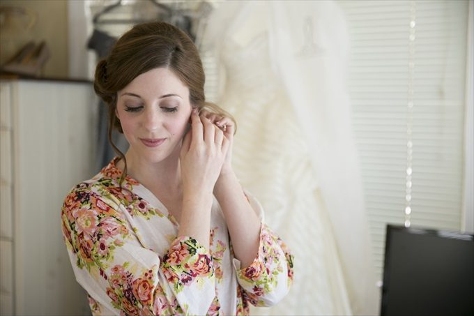 bride putting on earrings in this Crystal Coast Wedding | North Carolina wedding photographed by Ellen LeRoy Photography - https://emmalinebride.com/real-weddings/breathtaking-crystal-coast-wedding-mara-will-married/