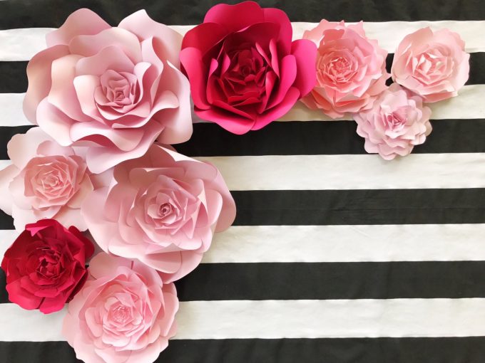 paper flowers in hot pink and light pink on a black and white striped background