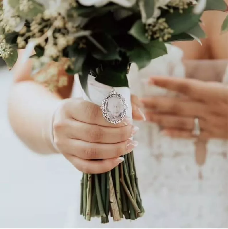 Photo locket attached to bouquet in honor of loved one at wedding