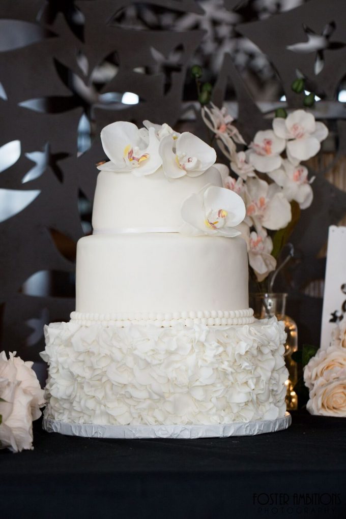 the wedding cake was topped with orchids