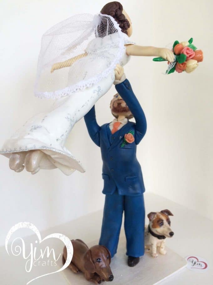bride lifted by groom cake topper