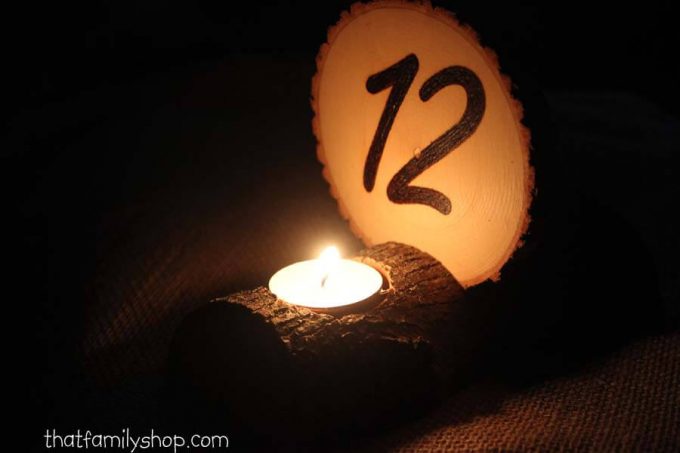 wood slice table number with candle holder lit up at night