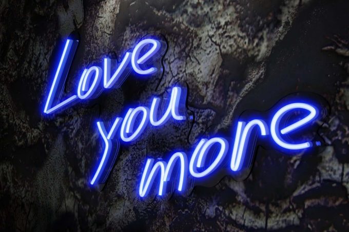neon sign that says love you more