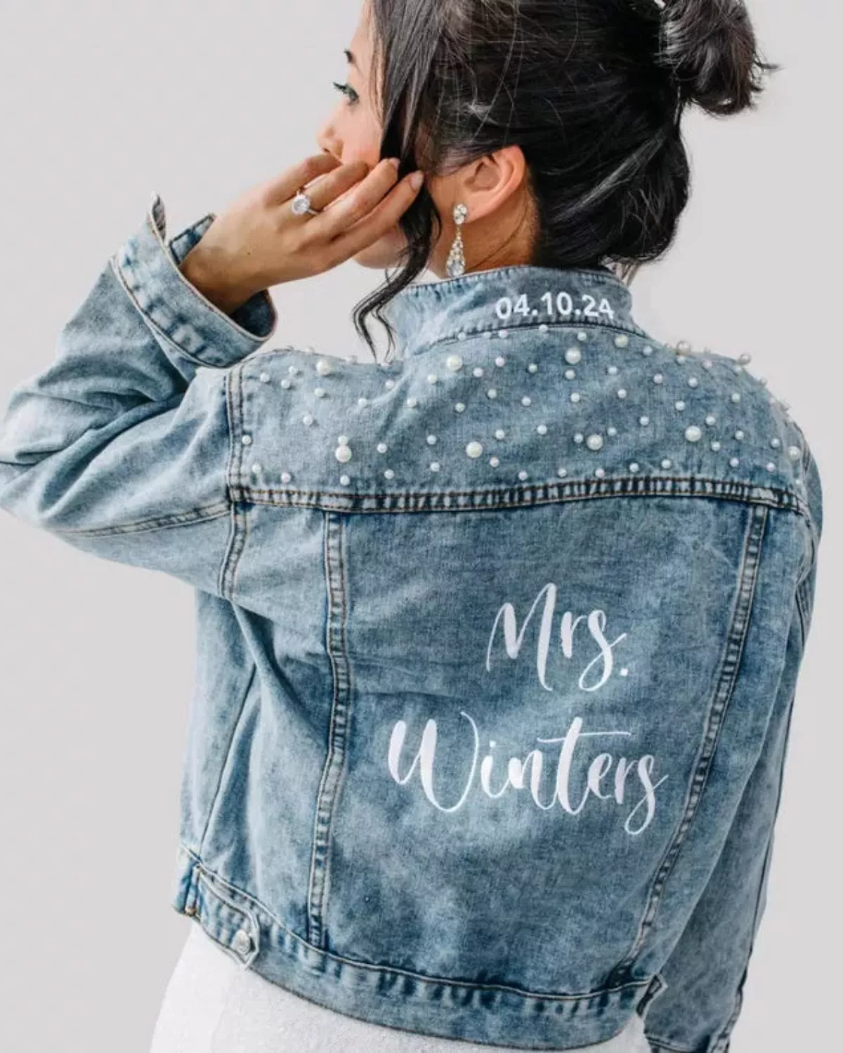 Bride wearing a custom bride denim jacket over wedding dress