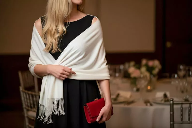 Wedding guest wearing an elegant wrap over a dress in cool weather