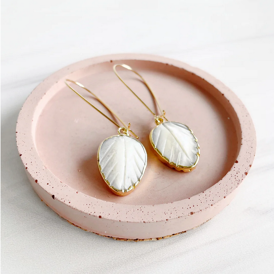 pearl leaf earrings made of mother of pearl on pink dish