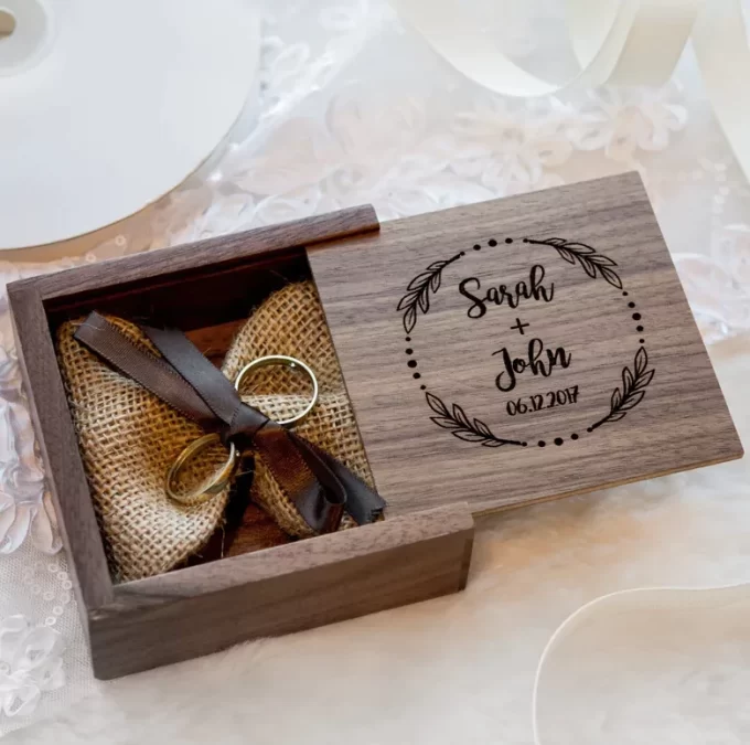 square wood ring box with engraving on the lid and burlap inside