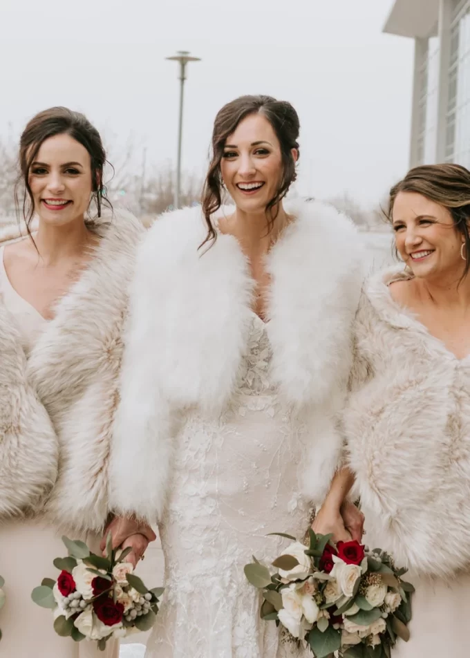 bride laughing wearing faux fur shawl winter wedding reception