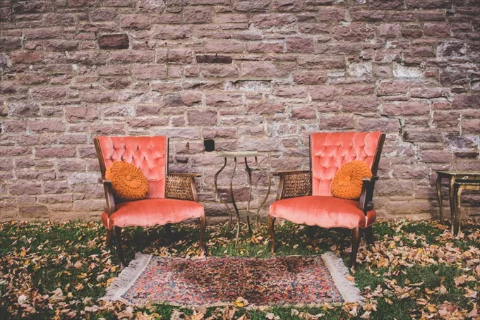 fall wedding lounge area for guests decorated with velvet chairs and an area rug