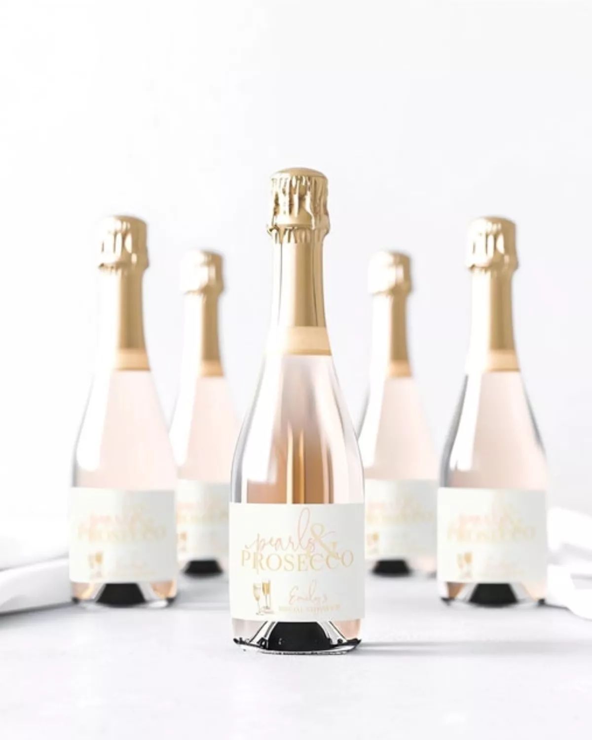 Custom Pearls and Prosecco bridal shower bottle labels on prosecco bottles with pastel décor and pearl accents