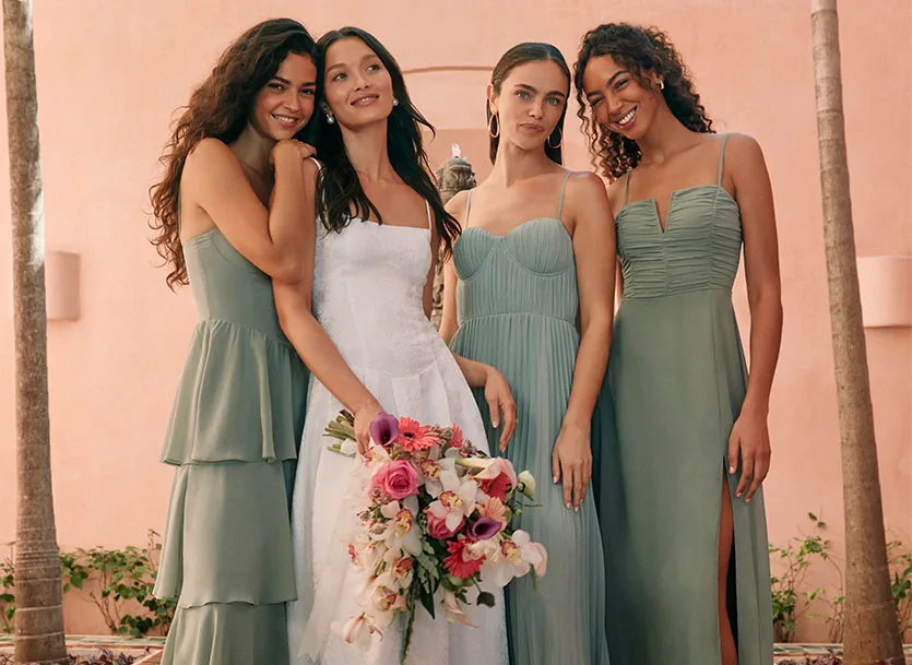 Bride and bridesmaids trying on dresses, discussing if bridesmaids pay for their own dresses