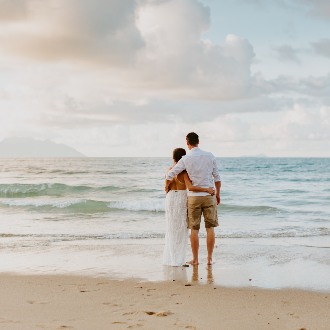 newlywed couple embracing on the beach
