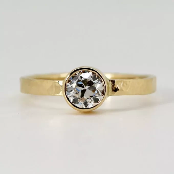 Natural diamond engagement ring with wide hammered gold band bezel set