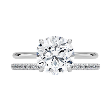 Round solitaire diamond engagement ring paired with diamond band