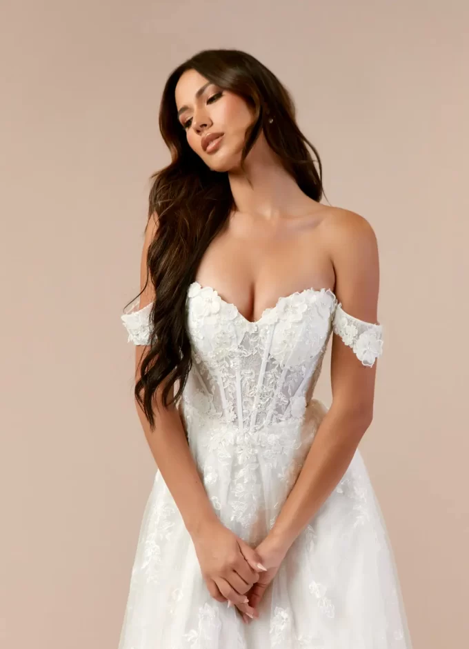 Bride wearing a diamond white Azazie wedding dress with off-the-shoulder neckline and lace