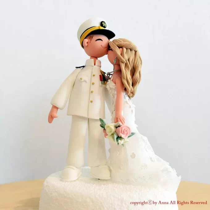 Navy wedding cake topper featuring couple and navy pilot in traditional military uniform