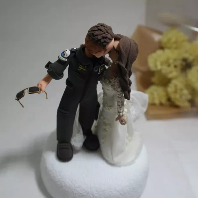 Air force pilot cake topper with groom kissing his bride in uniform