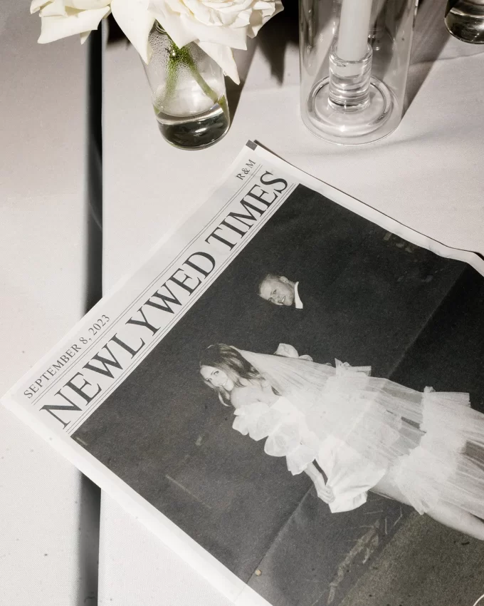 Wedding newspaper programs displayed on a table showing folded and unfolded designs.