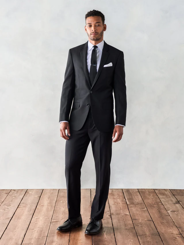 Groom dressed in black wedding suit with groomsmen