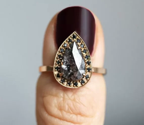 Pear shaped salt and pepper diamond engagement ring with black accents