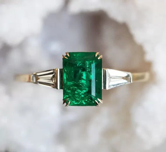 Emerald engagement ring with deep green stone in a vintage-inspired setting