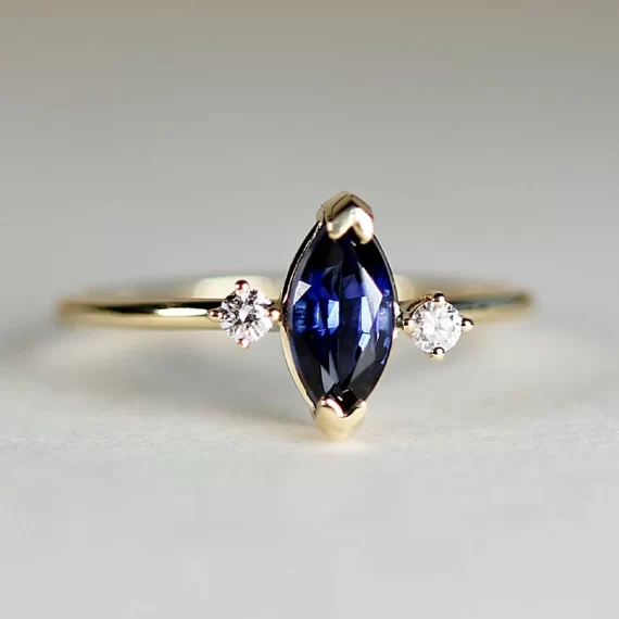 blue sapphire engagement ring with marquise shape and gold band