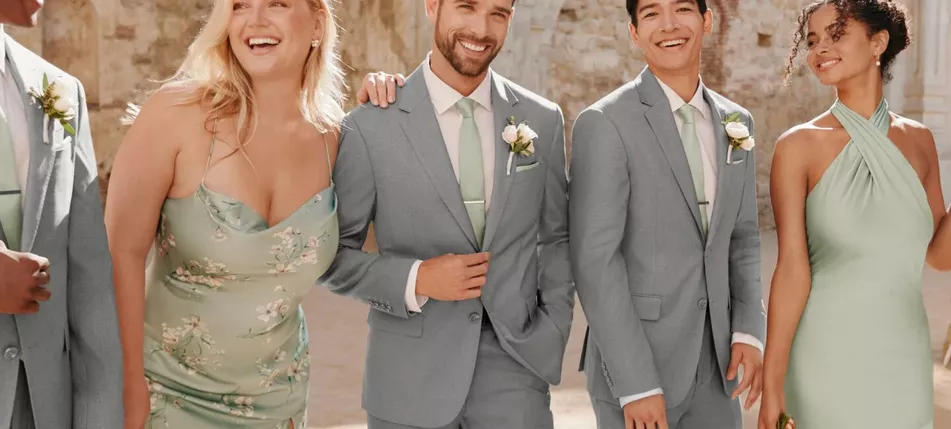 Full wedding party wearing Birdy Grey bridesmaid dresses and groomsmen suits, coordinated colors