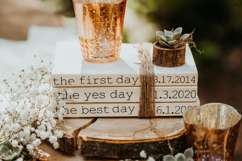Stacked books with plant and rustic wood slice - wedding centerpieces that aren't flowers