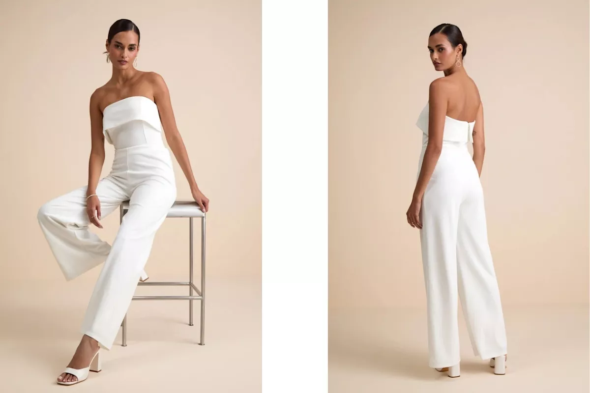 Bride wearing a white wide-leg jumpsuit with cross-front bodice at an outdoor wedding, styled with statement earrings and heels for ceremony and reception