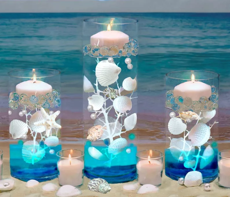 Coastal-themed wedding centerpiece with beach candle holders and ocean-inspired decor