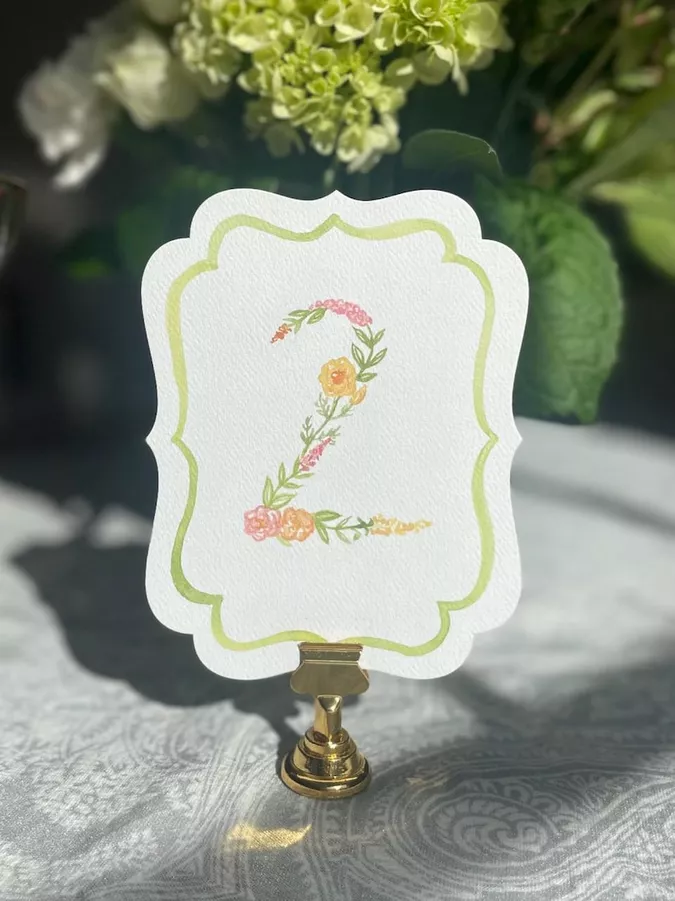 Hand-painted floral wedding table numbers surrounded by colorful flowers