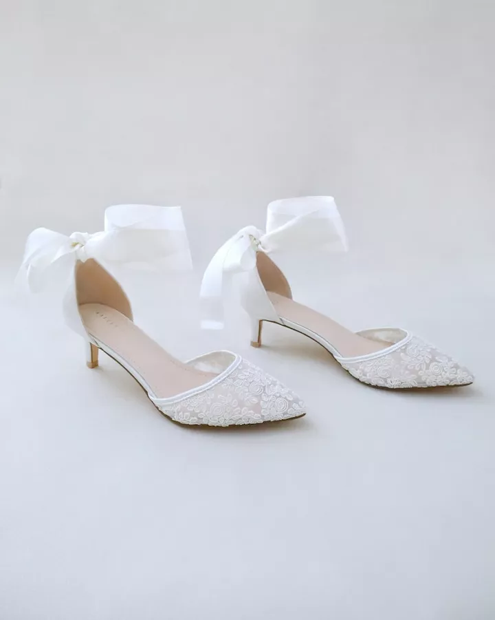 Ivory satin kitten heels worn by a bride on her wedding day