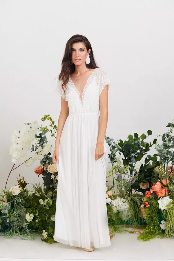Elegant boho wedding dress with lace details and flowing skirt, perfect for outdoor or rustic weddings