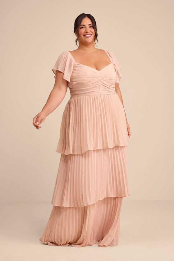 Plus size pink bridesmaid dress with pleated tiered skirt and bow on back