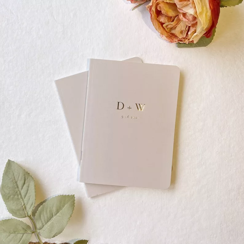 Identical vow books set with same colors and initials on the front that don't say his or hers labels