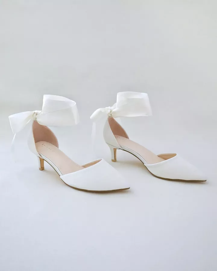 Bride wearing elegant kitten heel bridal shoes suitable for outdoor wedding on grass