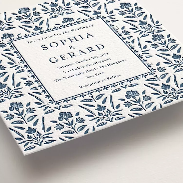 Luxury wedding invitation card with traditional letterpress printing on thick paper with floral pattern