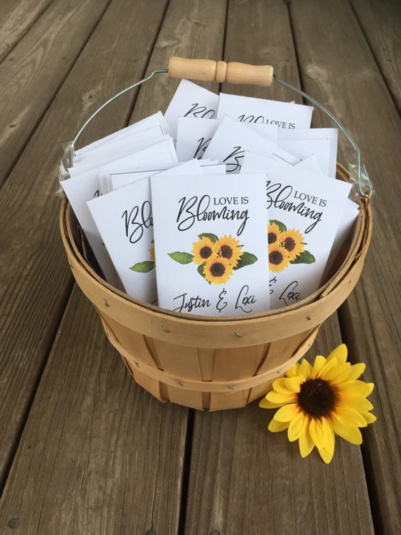 Sunflower seed packet wedding favors with personalized labels displayed on a rustic table