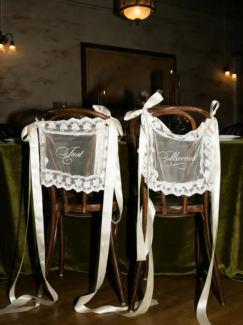 bride and groom chairs decorated with sheer lace Just Married signs