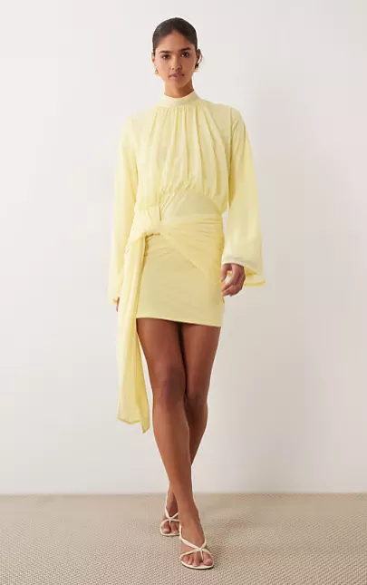 guest wearing lemon yellow beach wedding guest dress with long sleeves