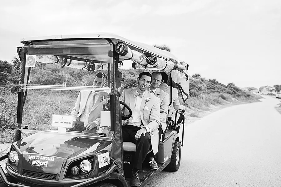 Groomsmen in golf cart for beach wedding wearing boat shoes