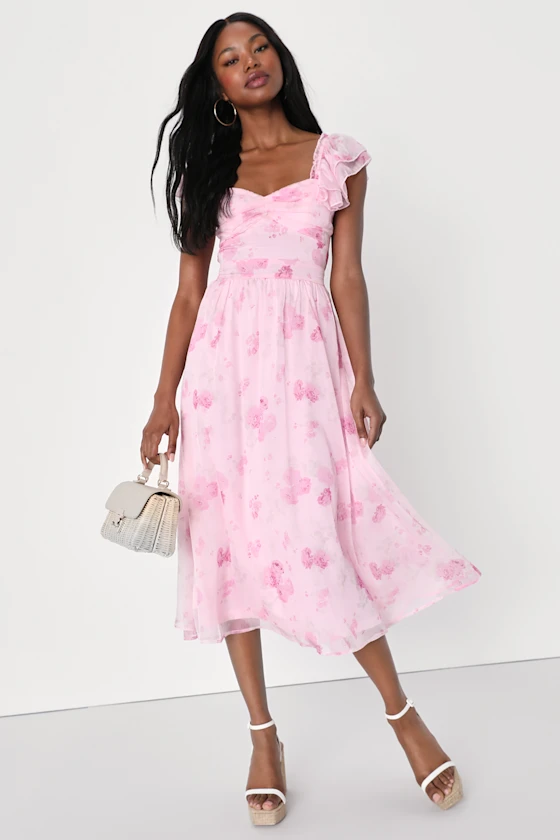 guest wearing ruffled sleeve pink floral midi dress for a beach wedding