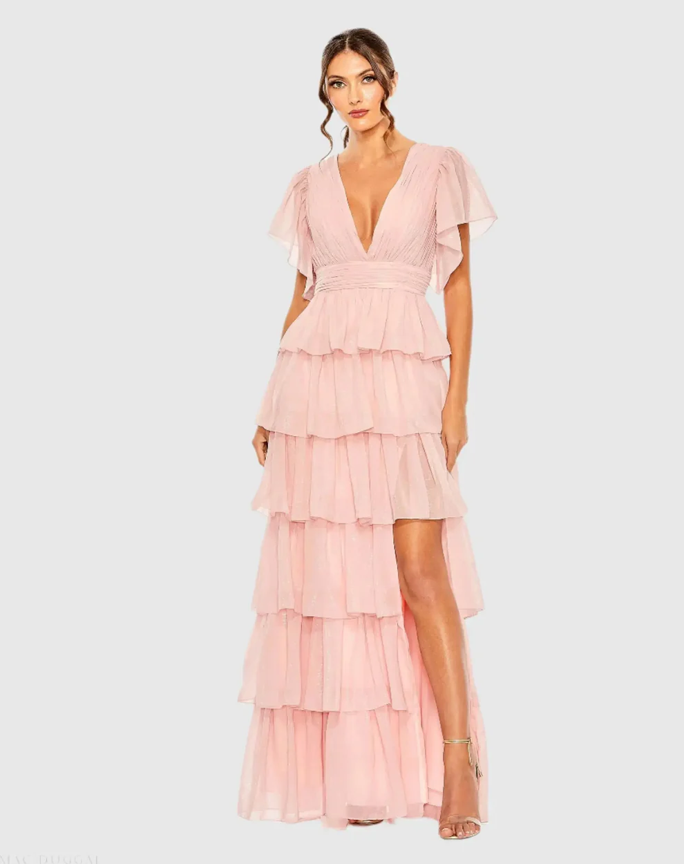 guest wearing pink beach wedding guest dress with sleeves that ruffle and flutter