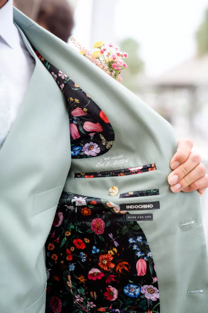 groom with custom embroidered jacket message from bride as gift on the wedding day