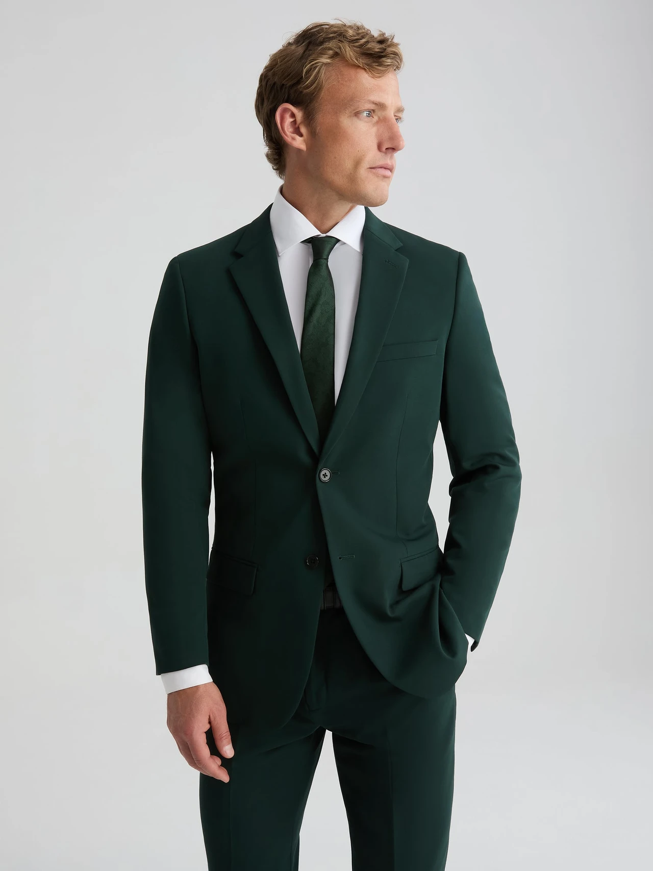 groom wearing dark green suit and tie with suit jacket